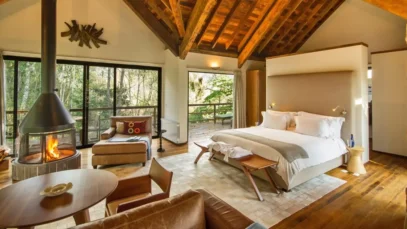 Staycation. Quarto de hotel com portas de vidro, em meio À natureza.