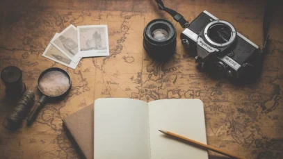 Viajar em segurança. Imagem mostra mapa aberta com caderno de anotações, máquina fotográfica e lupa.